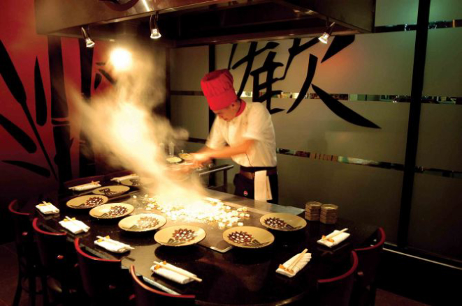 Enquanto cozinham, os chefs utilizam as espátulas para fazer espetáculos de malabarismo com os alimentos