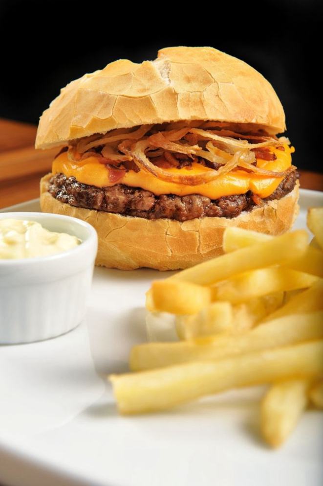 O Kharina Cheddar Burguer com cebola crocante, queijo cheddar, bacon, acompanhado de fritas e maionese é o mais vendido da rede. Foto: Divulgação.