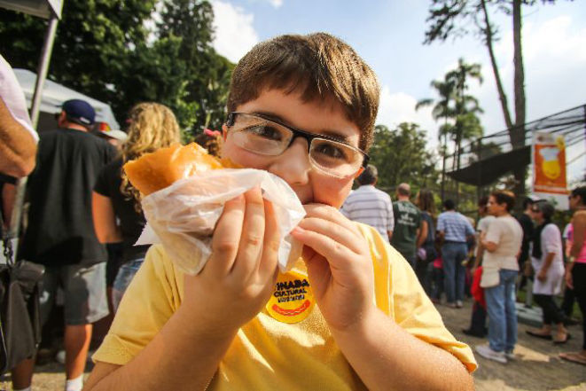 Garoto devora um dos lanches oferecidos na Vinada Cultural de 2013. Foto: Brunno Covello/Gazeta do Povo