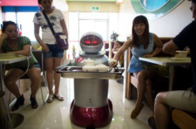 Robôs são os garçons de um restaurante no leste da China. Foto: Johannes Eisele / AFP.