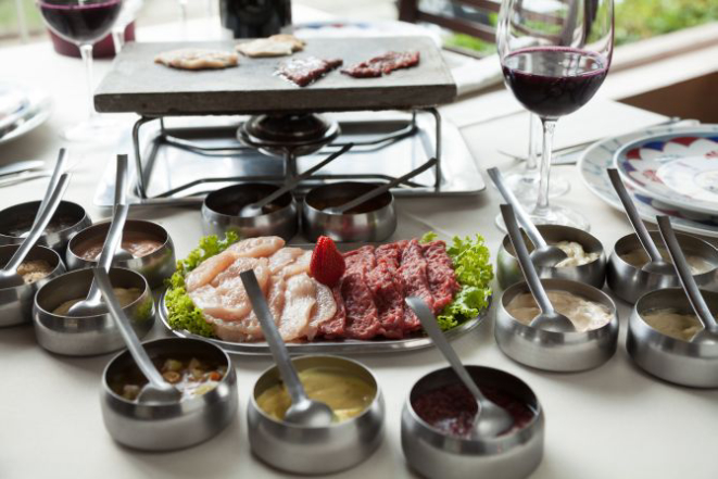 Fondue na pedra servido com 13 molhos, filé e frango laminados. Foto: Fernando Zequinão / Gazeta do Povo.