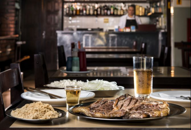 O churrasco paranaense está no cardápio do Bar Palácio há décadas. O t-bone (500 g de filé e contrafilé) vem à mesa acompanhado de arroz, cebola e farofa (R$ 38). Foto: Letícia Akemi/Gazeta do Povo