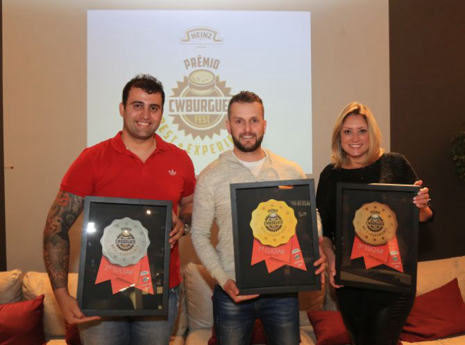 Fábio Roberto Baggio, da Celeiro Hamburgueria (ao centro) foi o grande vencedor do CWBurguer Fest. Ao seu lado Rafael Gonçalves, da Bella Banoffi, segunda colocada, e Cleide Cavalheiro, da Fábrica Gourmet Hamburgueria, terceiro lugar. Foto: Pedro Serapio/Gazeta do Povo.