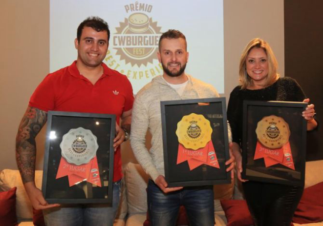 Fábio Roberto Baggio, da Celeiro Hamburgueria (ao centro) foi o  vencedor do CWBurguer Fest. Rafael Gonçalves, da Bella Banoffi, ficou em 2º lugar, e Cleide Cavalheiro, da Fábrica Gourmet Hamburgueria, em 3º. Foto: Pedro Serapio/Gazeta do Povo