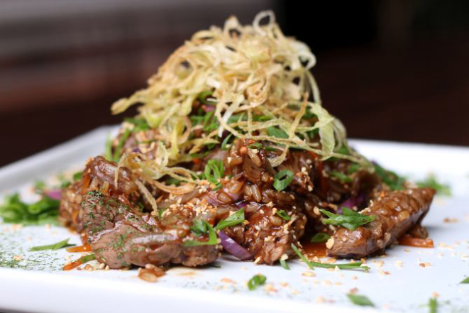 Nasi Goreng de mignon (R$ 35,90) temperado com cebola, cenoura, repolho roxo, broto de feijão, castanha de caju moída e alho-poró crocante. Foto: Divulgação.