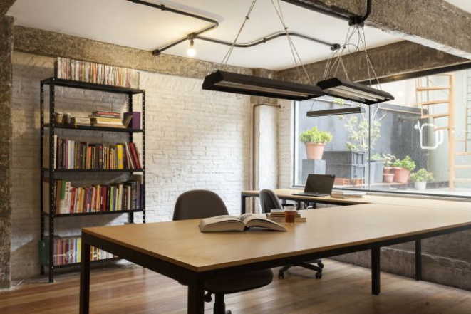 Parte do escritório no segundo andar do Coletivo Alimentar. A janela dá para o terraço onde há uma horta de temperos e uma composteira. Do outro lado, fica a cozinha, ainda não reformada, e a escada caracol que dá acesso ao telhado onde será instalada uma horta urbana. Foto: Fernando Zequinão/Gazeta do Povo