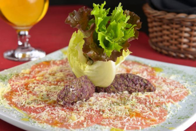 Carpaccio de carne com grana padano e tapenade de azeitonas. 