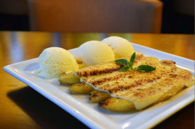 Cartola (R$ 19), sobremesa de origem nordestina à base de banana flambada cobertas com queijo gratinado e acompanhada de sorvete de creme. Foto: Divulgação.