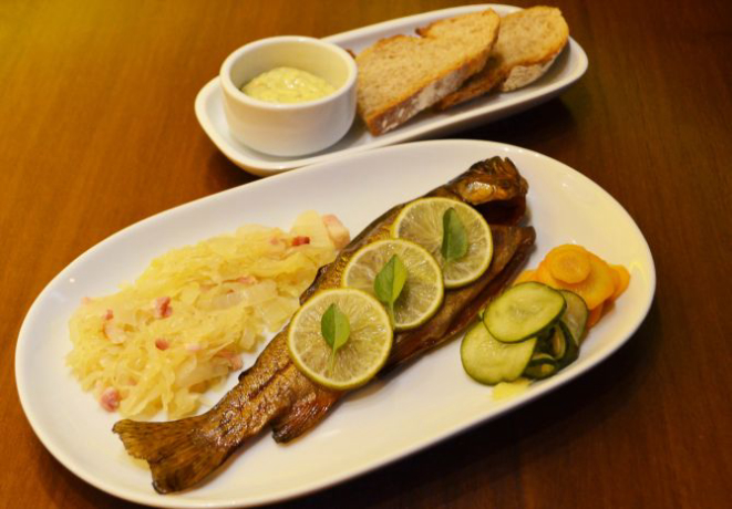 Truta defumada e assada, acompanha chucrute, molho tártaro e bauerbrot, pão típico suíço. Foto: Divulgação.