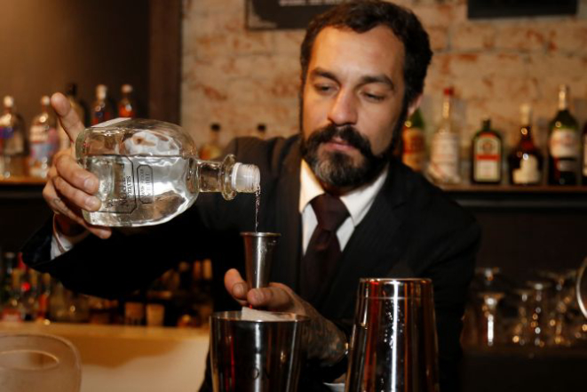 O bartender Igor Bispo, do Tiger Cocktails, tornou barba e bigode seu traço distintivo atrás do balcão. Foto: Pedro Serapio/Gazeta do Povo.