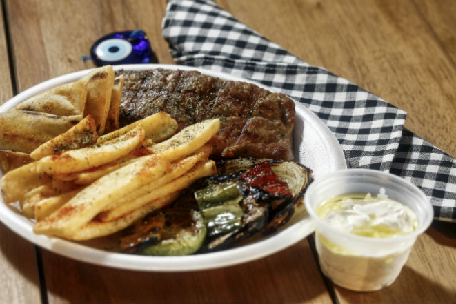 Um dos pratos do Kalamata: Psaronêfri - mignon suíno ao alho e orégano com salada de cebola, pimentão, abobrinha e beringela; e batatas fritas à grega (R$ 29). Foto: André Rodrigues.