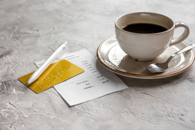 restaurant bill, credit card and coffee on stone table background