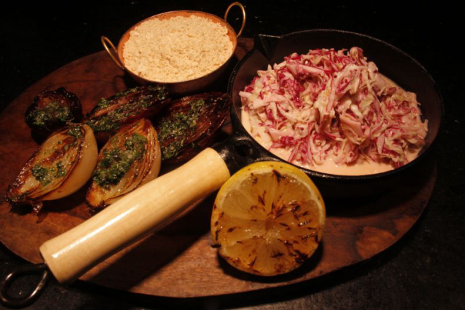 Coleslaw (repolho cru com molho), cebolas assadas e farofa. O prato também<br>vem com banana frita e arroz branco. Foto: Grasilei Félix/Divulgação.