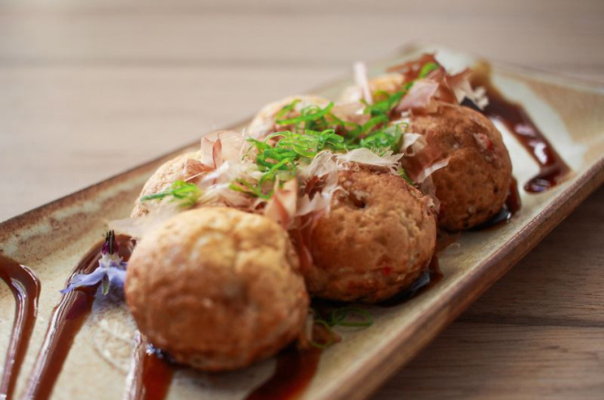 Takoyaki é um bolinho de massa recheado com polvo e gengibre e coberto por cebolinha e katsuobushi. Foto: Divulgação.