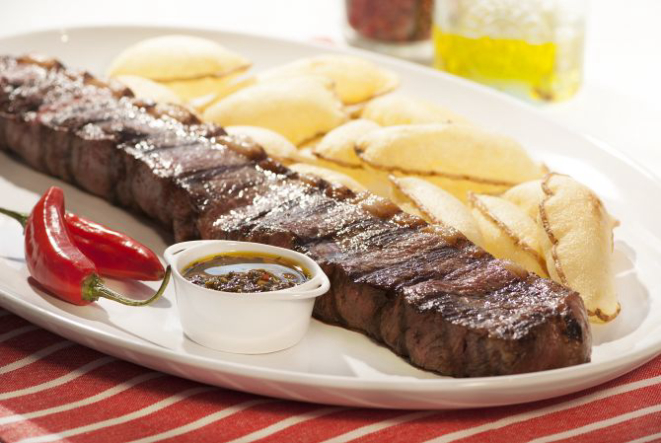 Bife de tira acompanhado de batatas suflê e molho chimichurri. Foto: Divulgação.