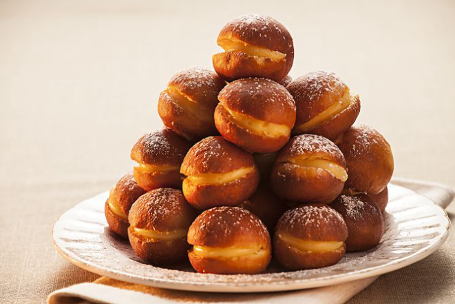 Foto da capa: sonhos recheados com creme de maracujá de Karyne Iancóski, chef pâtissière da Bazar Doce. A confeitaria começou com doces franceses e hoje foca em receitas brasileiras “de vó”.