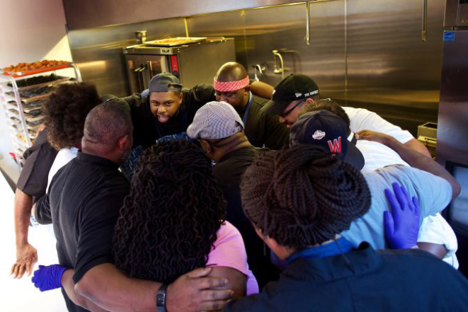 Chef Greg Collier, no centro, lidera os chefs da Soul Food Sessions em um momento de solidariedade antes de começar a trabalhar. Foto: Deb Lindsey/The Washington Post