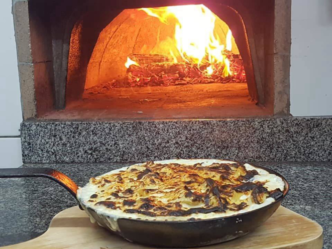 As batatas com gruyére devidamente tostadas, na boca do forno à lenha do Armazém Santo Antônio. 