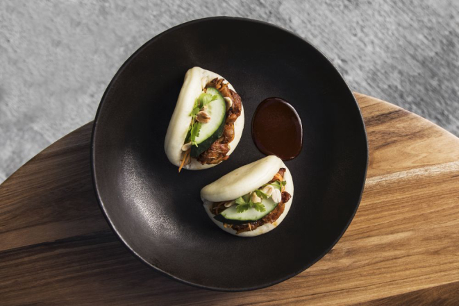 Bao (pão cozido no vapor) recheado de jaca braseada, pimenta gochujang e milho, com amendoim e pepino japonês fresco. Foto: Divulgação/SACRO