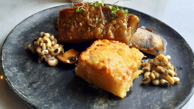 Costela gaita de Angus, assada lentamente, acompanhada de gratin de aipim e salada de feijões (moyashi e fradinho).