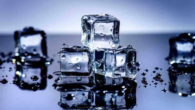 Iced cubes melting on a black table with reflection. Water. Melting of ice.