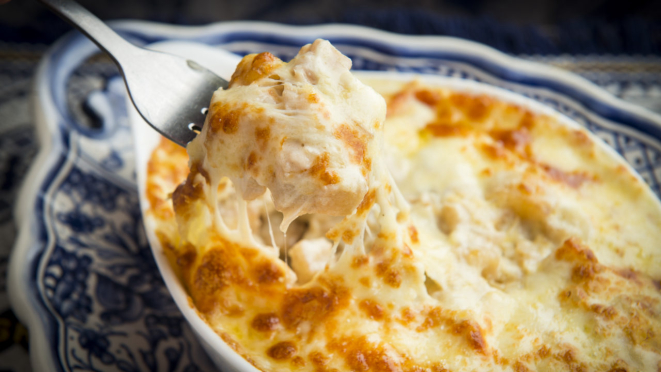 No Bacalhau às Natas, o bacalhau é desfiado e servido com nata, batatas ao cubo, cebola e queijo gratinado.