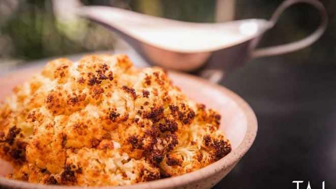 Assada com temperos especiais, a couve-flor defumada do Taj é acompanhada por uma fonduta de queijo.