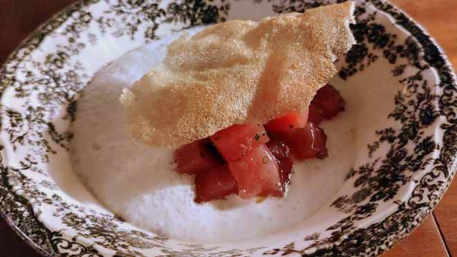 Atum cru em cubinhos, servido com leite de coco feito na casa, temperado com gengibre, sorbet de lichia e crocante de batata.