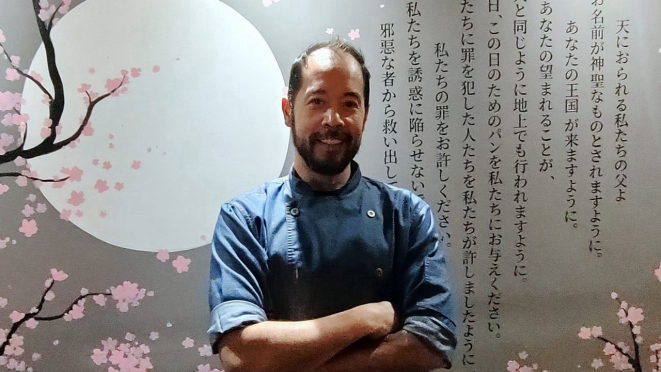 O moçambicano Fernando Wei Man Siu, de ascendência chinesa e perito da comida japonesa. Com o “Pai Nosso”, a oração, Inori, na parede.