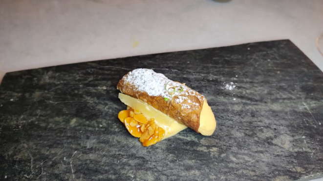 Cannoli recheado de creme praliné, acompanhado de compota de limão. 