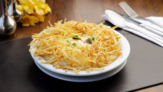 Camarões refogados com alho e cebola, arroz cremoso com manjericão e molho branco, gratinado com queijo muçarela e batata-palha, do Coco Bambu. 