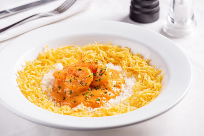 Strogonoff de camarão, servido com arroz e batatas palha. 