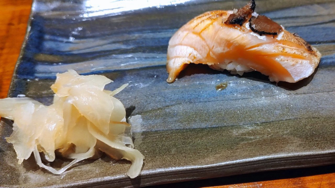 Barriga de salmão gordo com lasca de unagui (enguia), trufa negra e flor de sal.