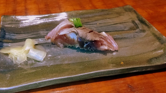 Sushi niguiri de carapau ao molho de fumaça e cebolinha.