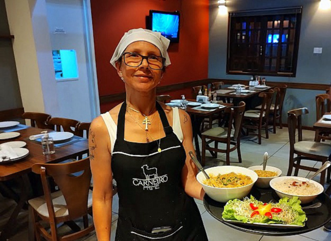 A chef Vânia Oliveira chega à mesa para servir o Estrogonofe de língua de cordeiro. 