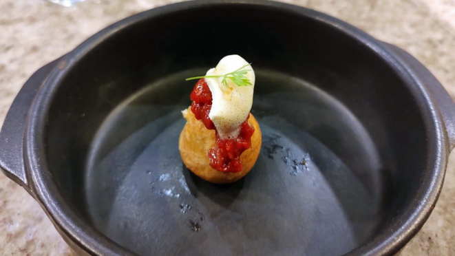 Pão de queijo, carne cruda, creme de alho assado e neve de parmesão.