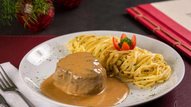 O restaurante serve filé mignon ao molho de queijo roquefort acompanhado de fettuccine.  