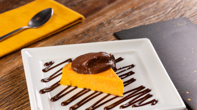 Fatia de torta de cenoura, coberta com ganache de chocolate meio amargo no Famiglia Fadanelli.