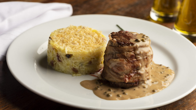 Filetto ao pepe verde: medalhão de filé mignon grelhado, envolto em bacon, servido com molho de pimentas verdes, acompanhado de rösti de batata com bacon picado, opção do Cantina Famiglia Fadanelli.