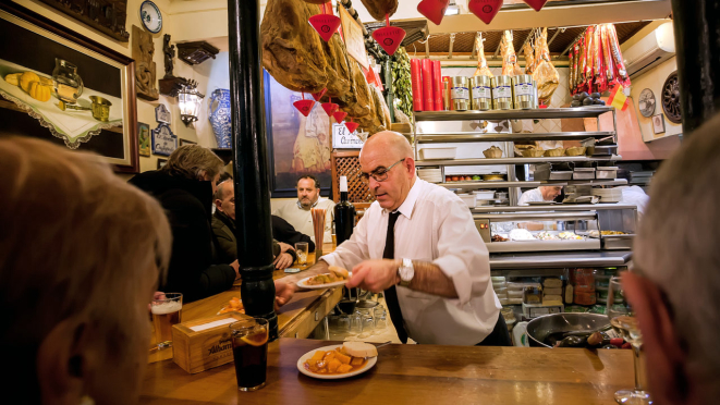 Bar de tapas autenticamente espanhol, com direito a jamón pendurado no teto. Foto: Bigstock