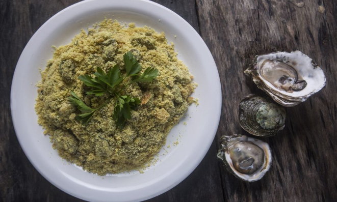 Preparo de ostras e farinha de mandioca no Restaubar Ostras e Cataia, em Cananéia, na Região Turística Lagamar.