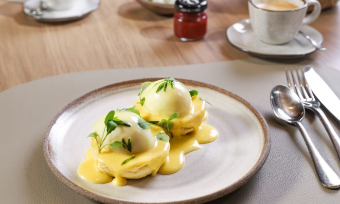 O preparo de Ovos Benedict servido no café da manhã do Koré.