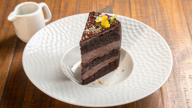 O Wills Cais traz bolo de chocolate em camadas de chocolate com fava de cumaru defumado, acompanhado de leite maltado.