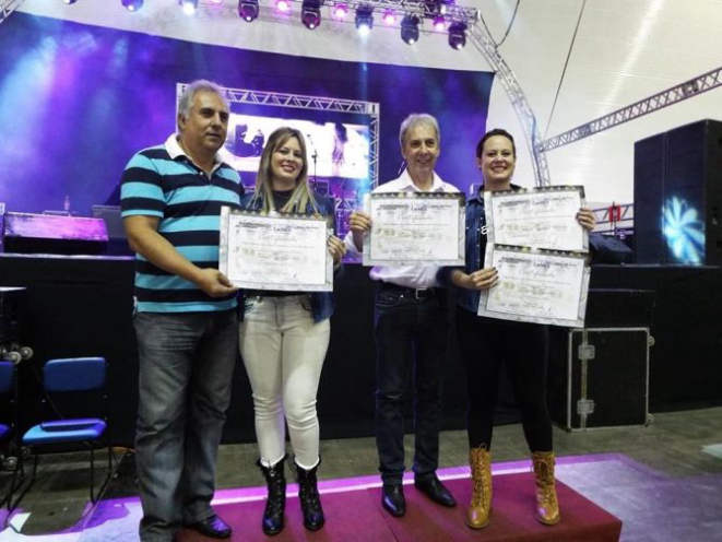 Luiz Vicente Mendes e José Lúcio Mendes Ferreira, organizadores do Expocachaça, entregam o prêmio às diretoras da Cachaçaria Companheira Sara de Brito Bonicontro e Raquel de Brito Bonicontro. Foto: Divulgação.