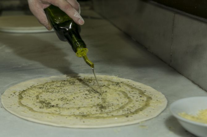 Finalize polvilhando orégano e queijo. Adicione um fio de azeite. Coloque no forno à lenha ou no forno elétrico a 200 graus C até dourar. Foto: Marcelo Andrade/Gazeta do Povo