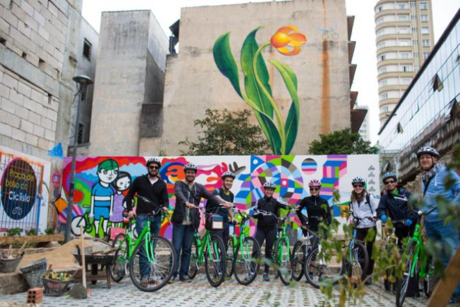 A turma parou na Praça do Bolso do Ciclista para tirar uma foto para recordação. Foto: Brunno Covello / Gazeta do Povo.
