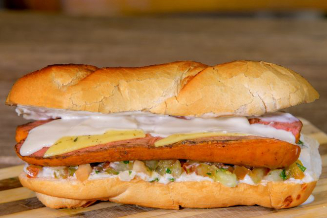 O sanduíche do alemão, do Aufenhaus, vem com salsichão tipo alemão de carne suína com 20 cm, queijo muçarela derretido, molho defumado, vinagrete com cebola, tomate e limão. Custa R$ 15,90. Foto: Divulgação