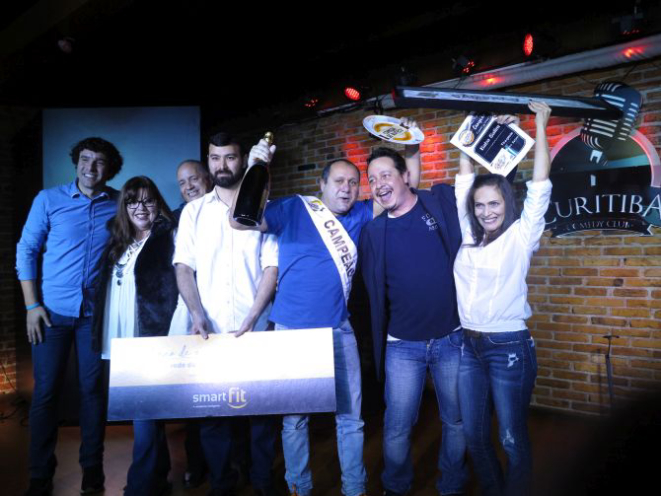 Jamal Chiah, com a faixa, e a esposa Nazha (dir.) comemoram a vitória da terceira edição do Comida di Buteco. Foto: Andrea Torrente/gazeta do Povo.