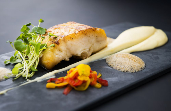 Lombo de bacalhau assado é servido com purê de batata e alho, confit de pimentão e espuma de azeitona preta (R$ 79). (Foto: Letícia Akemi/Gazeta do Povo)