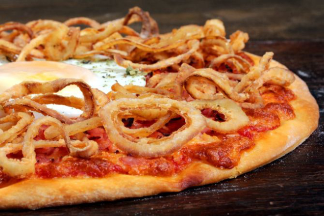 Pizza Sophia Loren servida com um ovo estrelado ao meio e cebola crocante. Foto: Divulgação